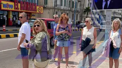 سياح يلتقطون صورًا تذكارية مع صور الرؤساء بكورنيش الإسكندرية