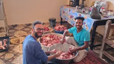 سائح إيطالي يشارك أهالي الضبعية في تجهيز لحوم الأضاحي بالأقصر