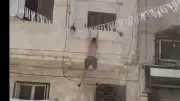 فيديو يحبس الأنفاس.. رجل يهرب عاريًا من شرفة ويصمد بأعجوبة