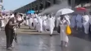 شاب يرش المياه على الحجاج لتخفيف حرارة الجو في مشهد إنساني مؤثر