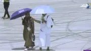 زوج يرش المياه على وجه زوجته لتخفيف حر الشمس في عرفات